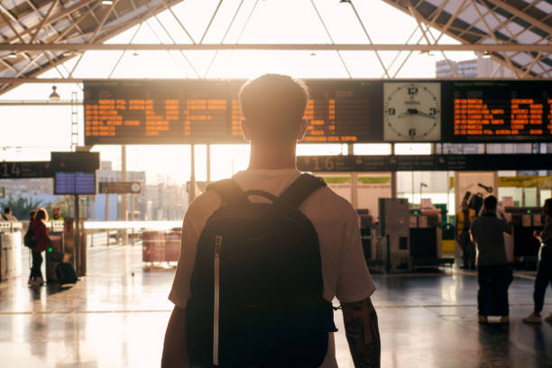istock Silhouette of a man with a backpack looking at a travel panel at sunset 1398323549