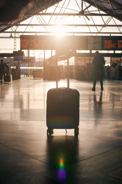 istock Suitcase in front of a destination board at a station at sunset 1398323550