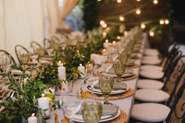 istock Table setting at the wedding reception. Floral compositions with beautiful flowers and greenery, candles, laying and plates on a decorated table. 1398324404