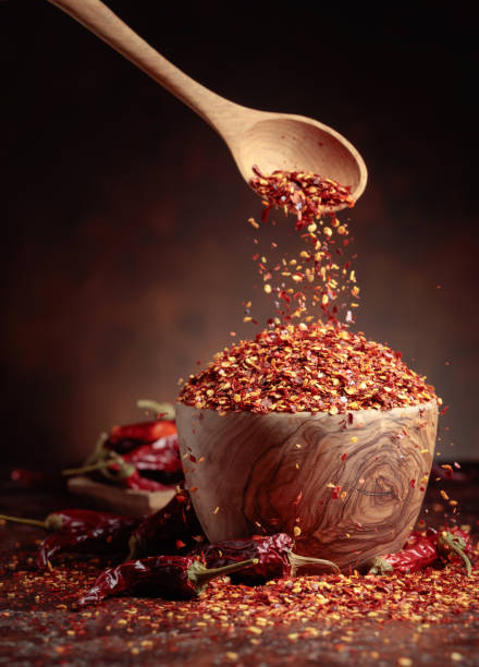 istock Chilli flakes are poured into a wooden dish. 1398324529