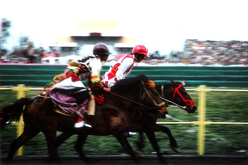 Sanyuejie Fair of Dali,Horse racing at a racetrack.Dali, in the west of Yunnan province, is a famous tourist city in China. The aborigines are the ethnic minority Bai Tribe.Sanyuejie Fair(or Third Month Fair) is their annual grand tradition festival.Film photo in April 1999's Dali,Yunnan