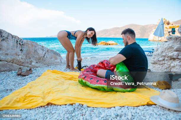 Couple At The Sea Beach Inflate Mattress And Inflatable Ring Stock Photo - Download Image Now