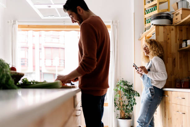 istock Couple laughing and standing in kitchen. 1398325890