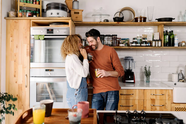 istock Couple laughing and standing in kitchen. 1398325905