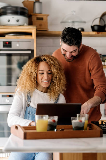 istock Couple looking at laptop in kitchen. 1398325958
