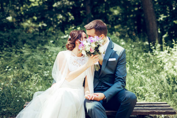 Beautiful couple relaxing on a foot bridge, near a lake, acting very romantic