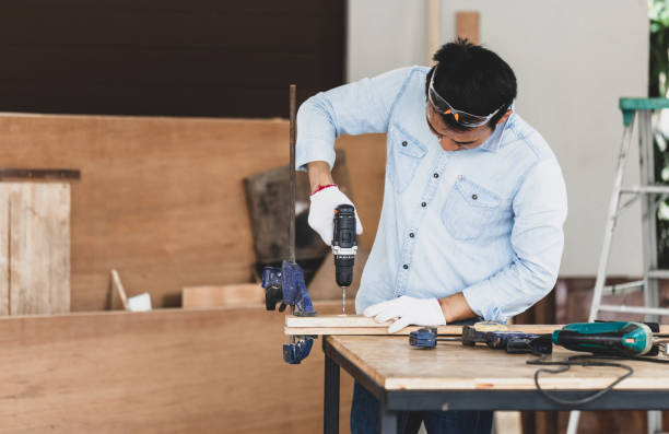 istock Carpenter working in wood workshop, Craftsman with drill in electric screwdriver, Man holding electric screwdriver drill, Male doing woodwork in a workshop 1398328708