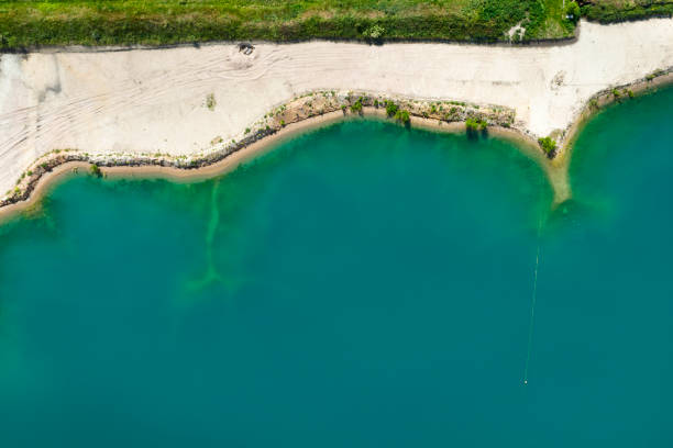 Gravel and sand open pit mining, pond with sediments - aerial view