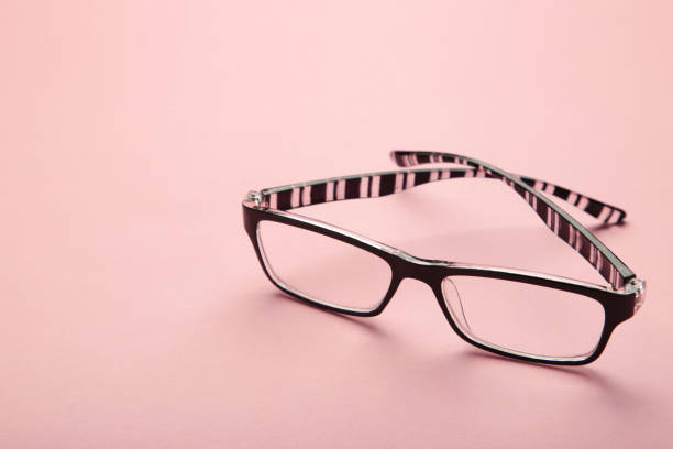 istock Black eye glasses spectacles with black frame for reading daily life to a person with visual impairment on pink background. 1398330976