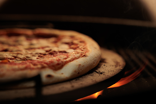close up view of a pizza margherita being cooked on a grill