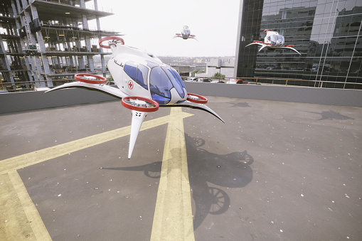 Ambulance eVTOL-Electric Vertical Take Off standing on rooftop landing pad between the buildings. (3d render)