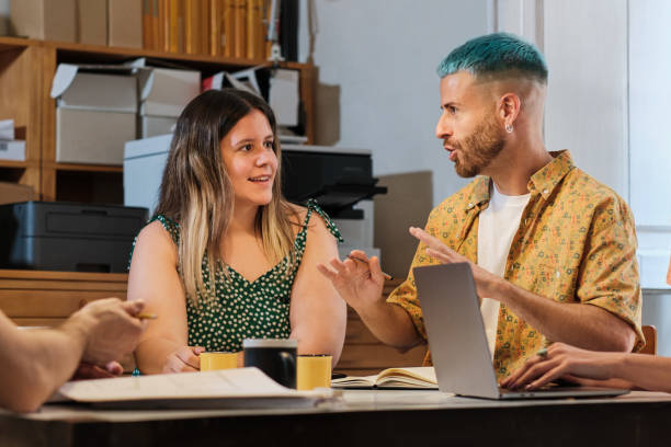 tiro médio de um dois colegas jovens falando em torno de uma mesa dentro de casa - blue hair - fotografias e filmes do acervo