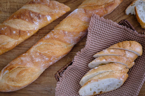 istock Fresh baguette with crispy crust on a wooden board 1398339912