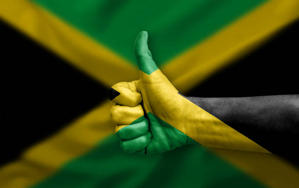 A vibrant watercolor illustration of the Jamaican flag featuring a bold green, black, and gold cross, with a decorative profile silhouette on the right, conveying national pride, culture, and artistic expression.