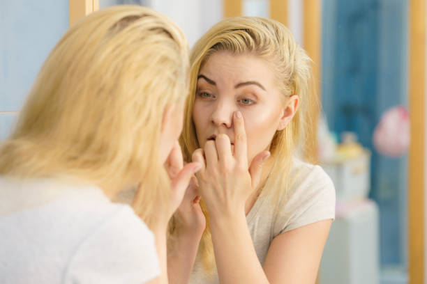 istock Woman looking at her skin in mirror 1398341247