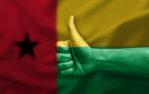 Hand making thumb up painted with flag of guinea bissau