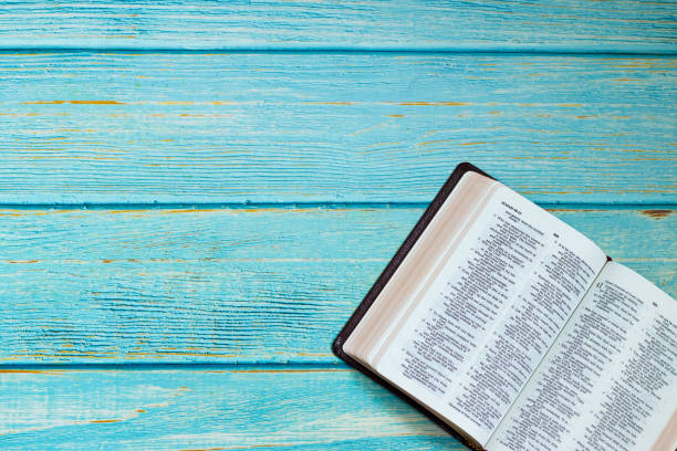 istock Open Holy Bible Book on a blue wooden table background with copy space, top view 1398342590