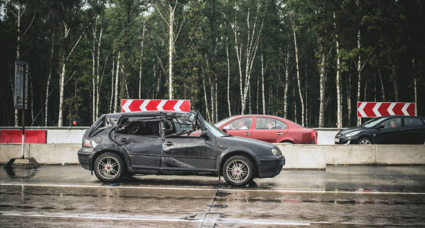 black hatchback car totally crashed after shunt with a truck due to drifting on wet and narrowed road, stands on roadside - hatchback volkswagen golf volkswagen side view imagens e fotografias de stock