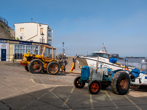 Crab fishermen in Cromer, Norfolk, Eastern England, who have just brought their boat ashore, hauled it up the slipway by tractor and are about to remove the morning’s catch of crabs and lobsters from the boat ready for sale.