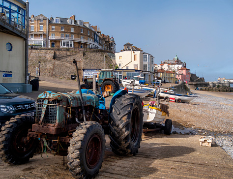 Tractors on the beach in Cromer, Norfolk, Eastern England. They are used for hauling the crab boats down to the sea and back again and are often quite old. Cromer is world-famous for crabs and lobsters.
