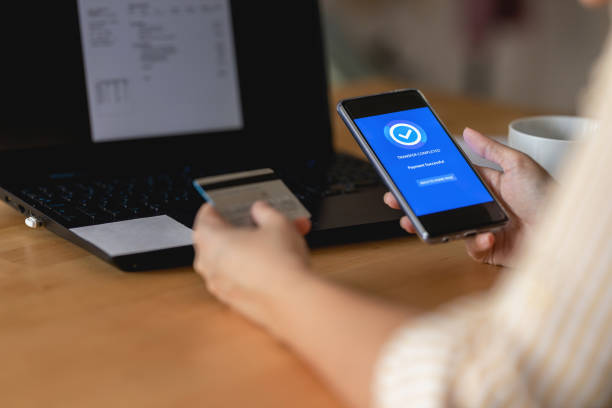istock Young woman Paying Bills with mobile phone 1398348217