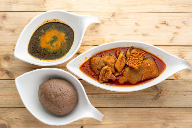 Amala and Ewedu Nigerian cuisine called Amala with Ewedu and assorted meat stew in 3 ceramic bowls on a wooden background from an overlay perspective nigeria stock pictures, royalty-free photos & images