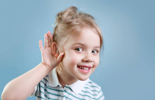 子供が聞く。難聴、症状および治療概念。子供の肖像画。ゴシップとニュース。 - 耳 ストックフォトと画像