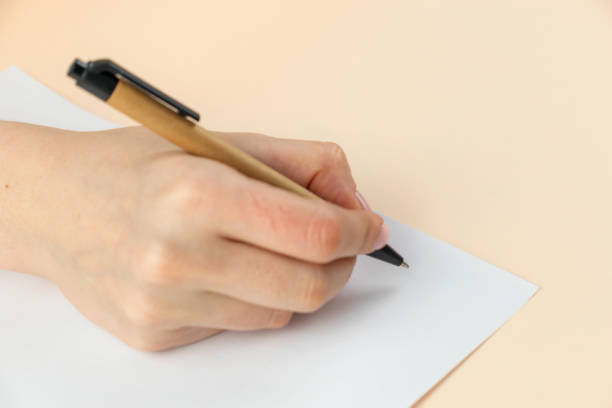 istock Closeup of woman's hand writing on paper, selective focus 1398350620