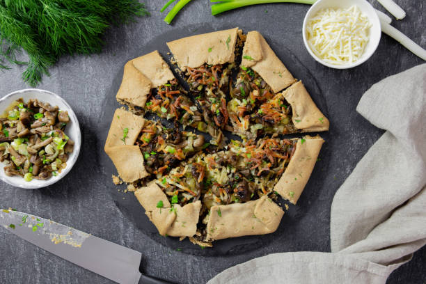 open pie, galette with wald mushrooms, fried green onions, fresh herbs and cheese filling. top view. - wald stok fotoğraflar ve resimler