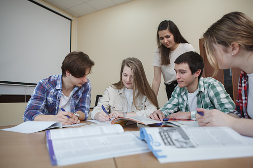 Young people studying together at college classroom