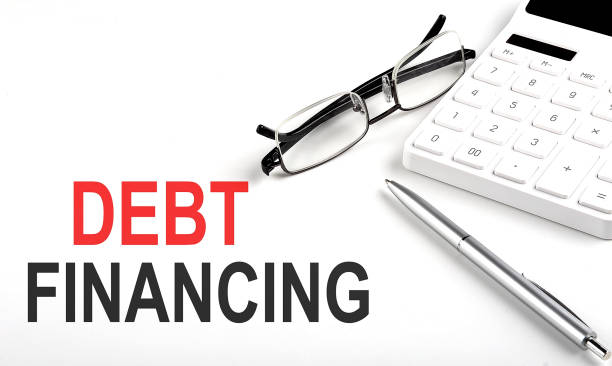 istock DEBT FINANCING Concept. Calculator,pen and glasses on white background 1398354300
