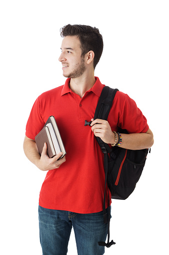 A latin Male student holding a backpack and books, standing and smiling away.