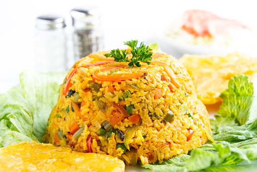 Chicken and Rice (Arroz con Pollo) Colombian dish and tostones from above on white background