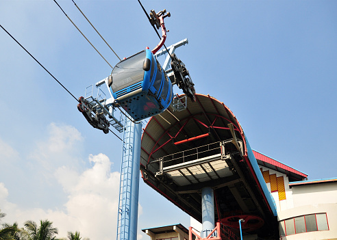 Jakarta, Java, Indonesia: gondola leaving an elevated station of the Ancol bay cable car, that travels along the waterfront, a favourite weekend destination.