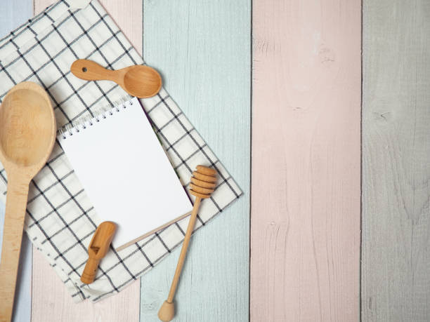 istock Notepad on cutting board with wooden kitchen utensils on the table, food recipes .copy space 1398359699