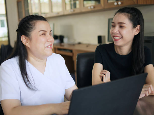 felices compañeras de trabajo asiáticas en el lugar de trabajo, incluida la persona con discapacidad de ceguera que usa una computadora portátil con un programa de lector de pantalla para personas con discapacidad visual. inclusión de la discapacidad e - e reader cheerful indoors lifestyles fotografías e imágenes de stock