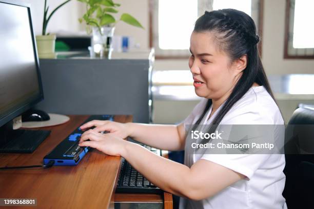 Asian Woman With Blindness Disability Using Computer With Refreshable Braille Display Or Braille Terminal A Technology Assistive Device For Persons With Visual Impairment In Workplace Stock Photo - Download Image Now