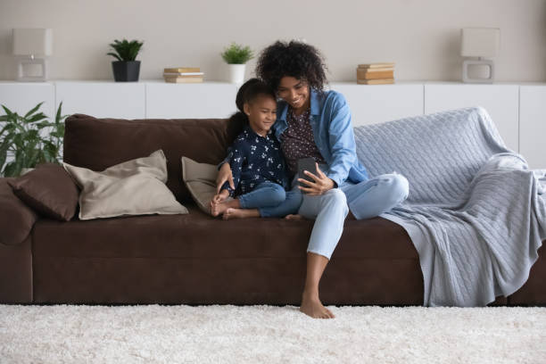 istock Bonding happy African American family using cellphone at home. 1398368977