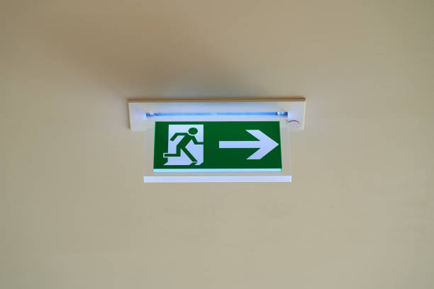 istock An emergency exit sign with an arrow pointing to the right hangs under a ceiling. 1398369181