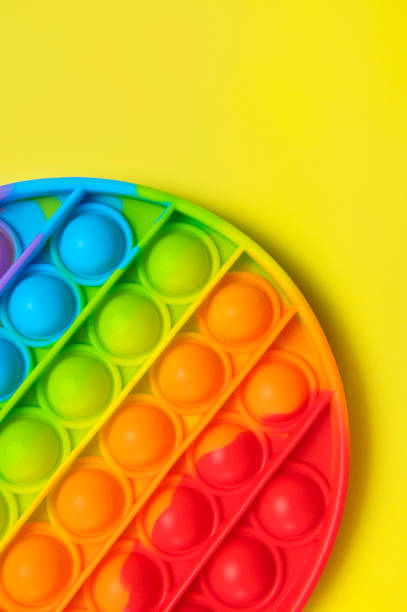 istock Popular silicone multi-colored anti-stress toy pop it on yellow background flat lay top view close-up. Trendy modern sensory children's toy, fidget push pop it. Abstract background 1398369213