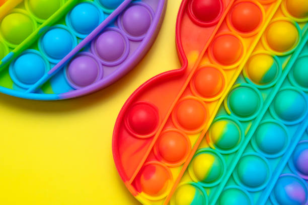 istock Popular silicone multi-colored anti-stress toy pop it on yellow background flat lay top view close-up. Trendy modern sensory children's toy, fidget push pop it. Abstract background 1398369232
