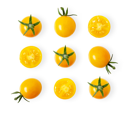 Pattern of yellow cherry tomatoes on white background with copy space.