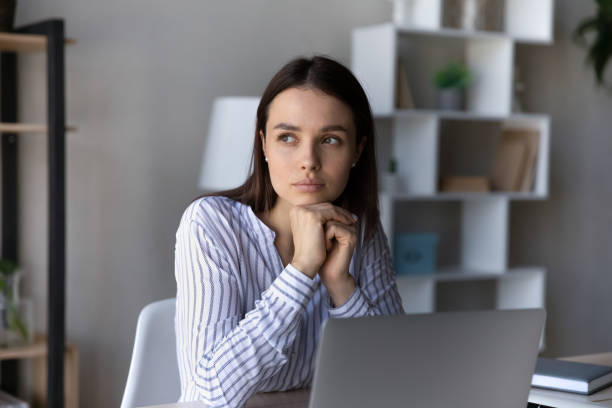 istock Serious thoughtful employee sitting at table with laptop 1398377558