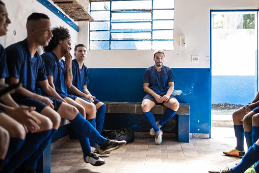 Soccer players sitting in locker room
