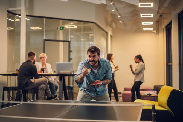 istock Young people playing table tennis in the office at work 1398379455