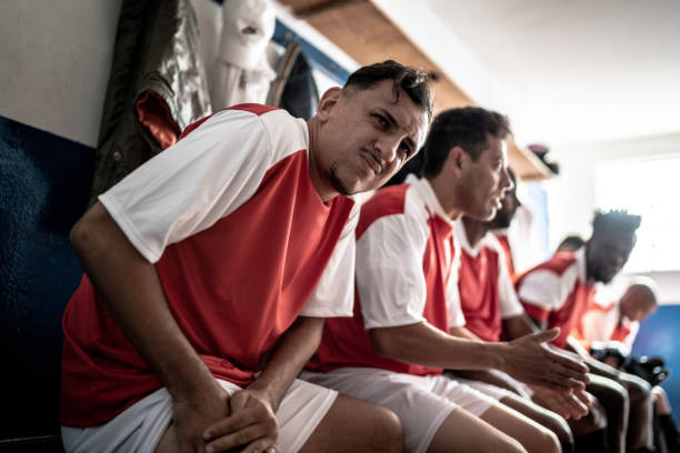 Injured soccer player pressing his thigh in the locker room Injured soccer player pressing his thigh in the locker room club soccer photos stock pictures, royalty-free photos & images