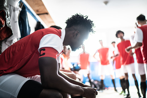 Focused soccer player before a match in the locker room