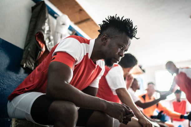 istock Focused soccer player before a match in the locker room 1398380242