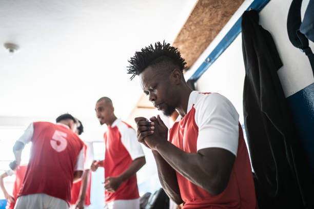 istock Soccer player praying before a match in the locker room 1398380270