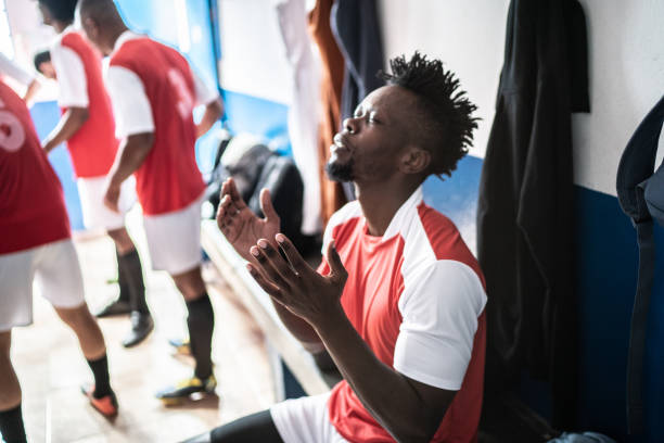 istock Soccer player praying before a match in the locker room 1398380280